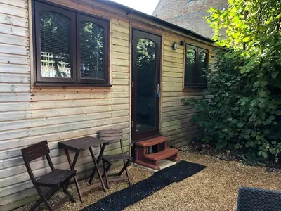 a picnic table and two chairs in front of a house at The Walnuts Country House in West Row
