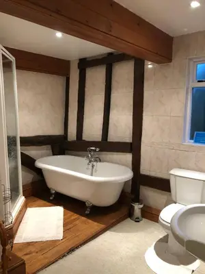 a bathroom with a tub and a toilet at The Walnuts Country House in West Row