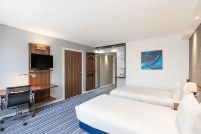 a hotel room with two beds and a flat screen tv at B&B Hotel Cambridge South in Cambridge