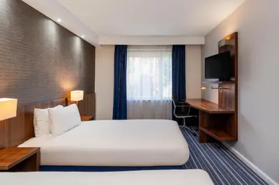 a hotel room with two beds and a television at B&B Hotel Cambridge South in Cambridge