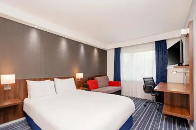 a hotel room with a large bed and a desk at B&B Hotel Cambridge South in Cambridge