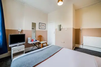 a hotel room with a bed and a television at Devine Beach Hotel, Westcliff Southend-On-Sea in Southend-on-Sea