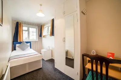 a small room with a bed and a bathroom at Devine Beach Hotel, Westcliff Southend-On-Sea in Southend-on-Sea