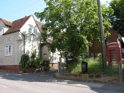 a red phone booth in front of a white house at Motts Bed & Breakfast in Great Dunmow