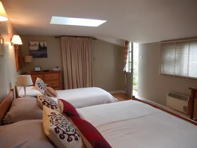 a hotel room with two beds and a window at Motts Bed & Breakfast in Great Dunmow