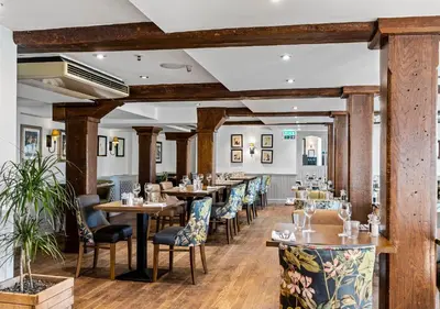 a row of tables and chairs in a restaurant at The Mill Hotel Sudbury in Sudbury
