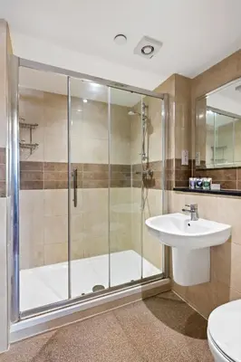 a bathroom with a shower and a sink at The Mill Hotel Sudbury in Sudbury