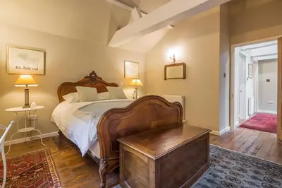 a bedroom with a large wooden bed with a wooden table at The Domek in Ashwell
