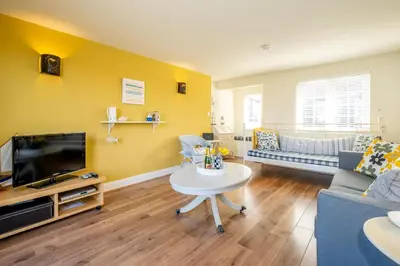 a living room with a couch and a table at 2 Bell Lodge, Thorpeness in Thorpeness