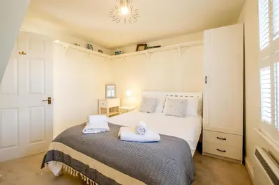 a bedroom with a bed with towels on it at 2 Bell Lodge, Thorpeness in Thorpeness