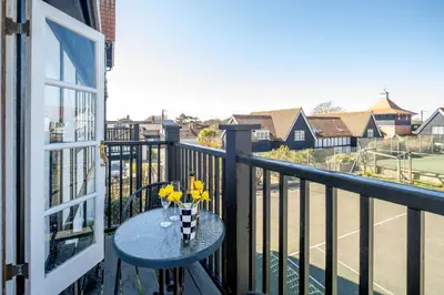 a balcony with a table with yellow flowers on it at 2 Bell Lodge, Thorpeness in Thorpeness