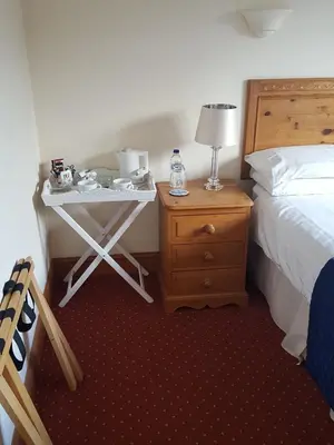 a hotel room with a bed and a table with a lamp at Byerley House in Newmarket