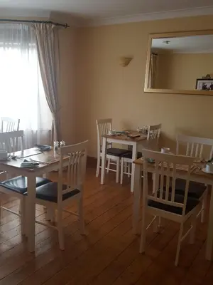 a dining room with tables and chairs and a mirror at Byerley House in Newmarket