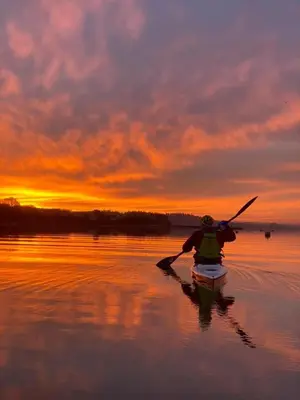 a person in a kayak on the water at sunset at Saurden Guest Apartment in Ipswich