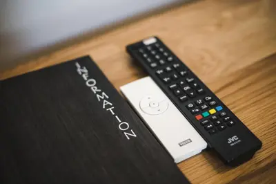 a remote control sitting next to a book on a table at The Red Lion in Cambridge