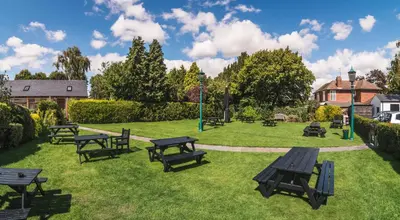 a group of picnic tables in the grass at The Red Lion in Cambridge
