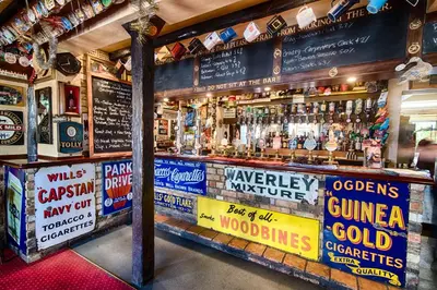 a bar with a lot of signs on the wall at The Red Lion in Cambridge