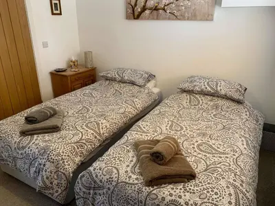 two beds sitting next to each other in a bedroom at Chestnut Cottage in East Bergholt