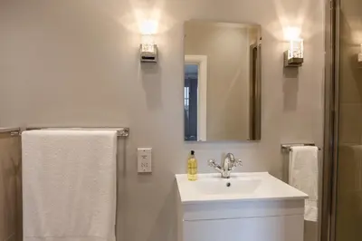 a white bathroom with a sink and a mirror at B&B Downham Hall in Wickford