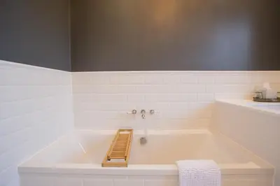 a bathroom with a bath tub with a towel at B&B Downham Hall in Wickford
