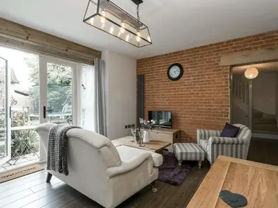 a living room with a couch and a table at The Coach House - Ukc2365 in Watton