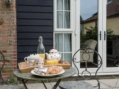 a table with a tray of food and drinks on it at The Coach House - Ukc2365 in Watton