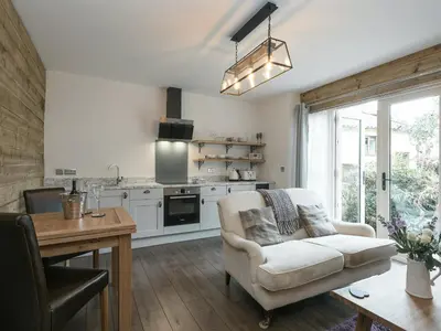 a living room with a couch and a kitchen at The Coach House - Ukc2365 in Watton