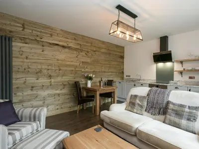 a living room with a wooden accent wall at The Coach House - Ukc2365 in Watton