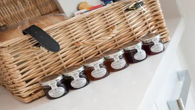 a group of jars of honey next to a basket at Tailored Stays - De Havilland House in Cambridge