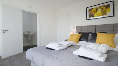 a bedroom with a bed with white towels on it at Tailored Stays - De Havilland House in Cambridge