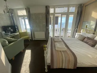 a bedroom with a large bed and a window at Pebbles Guest House in Southend-on-Sea