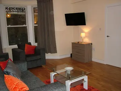 a living room with a couch and a tv at Stratford Apartment in Newmarket