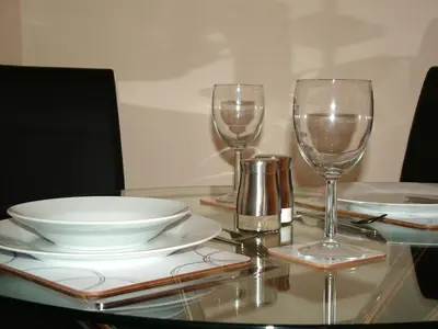 a table with two wine glasses and plates on it at Stratford Apartment in Newmarket