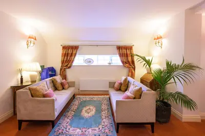 a living room with two couches and a rug at Rectory Farm in Cambridge