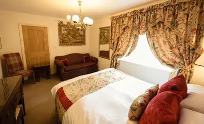 a bedroom with a bed and a chair and a window at Rectory Farm in Cambridge