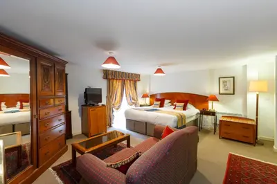 a hotel room with two beds and a couch at Rectory Farm in Cambridge