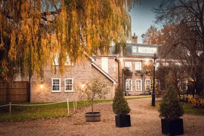 a large brick building with trees in front of it at Rectory Farm in Cambridge