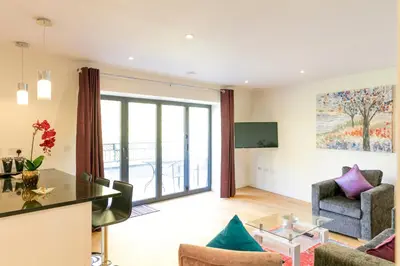 a living room with a table and chairs at Penthouse 5 mins walk to City Centre & Colleges with Balcony & Sleeps 6 in Cambridge