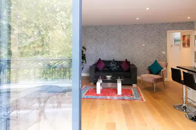 a living room with a couch and a table at Penthouse 5 mins walk to City Centre & Colleges with Balcony & Sleeps 6 in Cambridge