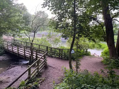 a wooden bridge over a river with a fence at Penthouse 5 mins walk to City Centre & Colleges with Balcony & Sleeps 6 in Cambridge