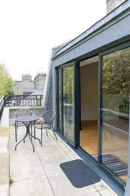 a patio with a table and chairs on a balcony at Penthouse 5 mins walk to City Centre & Colleges with Balcony & Sleeps 6 in Cambridge