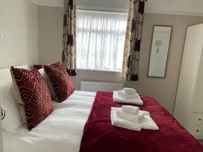 a bedroom with a bed with towels on it at The Sandrock in Clacton-on-Sea