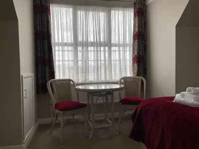 a room with a table and chairs and a window at The Sandrock in Clacton-on-Sea