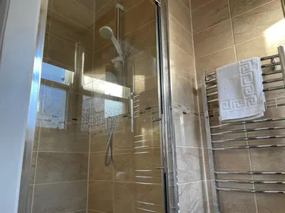 a shower with a glass door in a bathroom at The Sandrock in Clacton-on-Sea