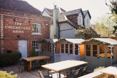 an outdoor patio with tables and a building at The Cricketers Arms in Quendon