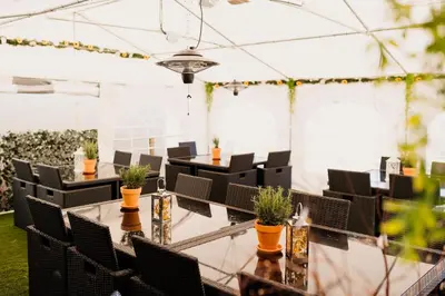 a conference room with tables and chairs and plants at The Cricketers Arms in Quendon