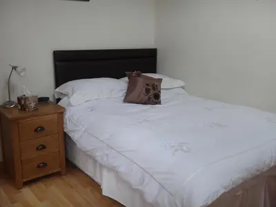 a bed with a pillow and a night stand at Leverton House in Cambridge
