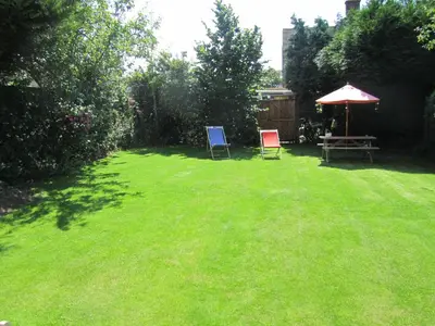 a yard with two chairs and a table and an umbrella at Leverton House in Cambridge