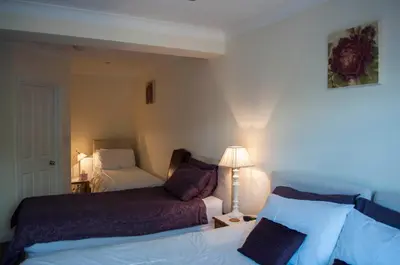 a hotel room with two beds and a lamp at Leverton House in Cambridge