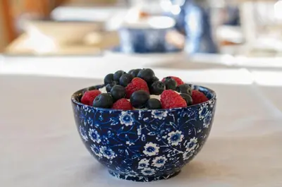 a blue and white bowl filled with berries on a counter at Leverton House in Cambridge